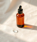 Vélume Multi-Weight Hyaluronic Serum bottle on ivory surface — placeholder concept photography