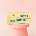 Viral Butter Squishy - slow rising butter bar squeeze toy styled on pink pedestal